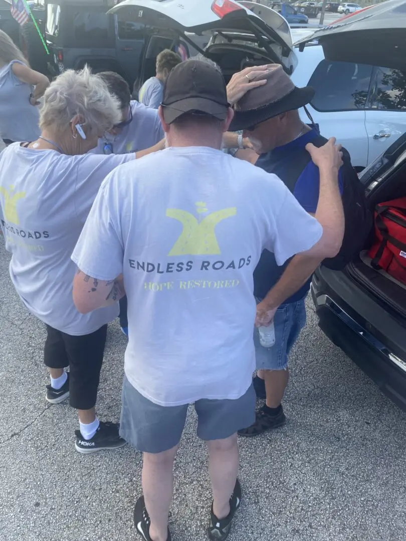 A group of people standing around a car.