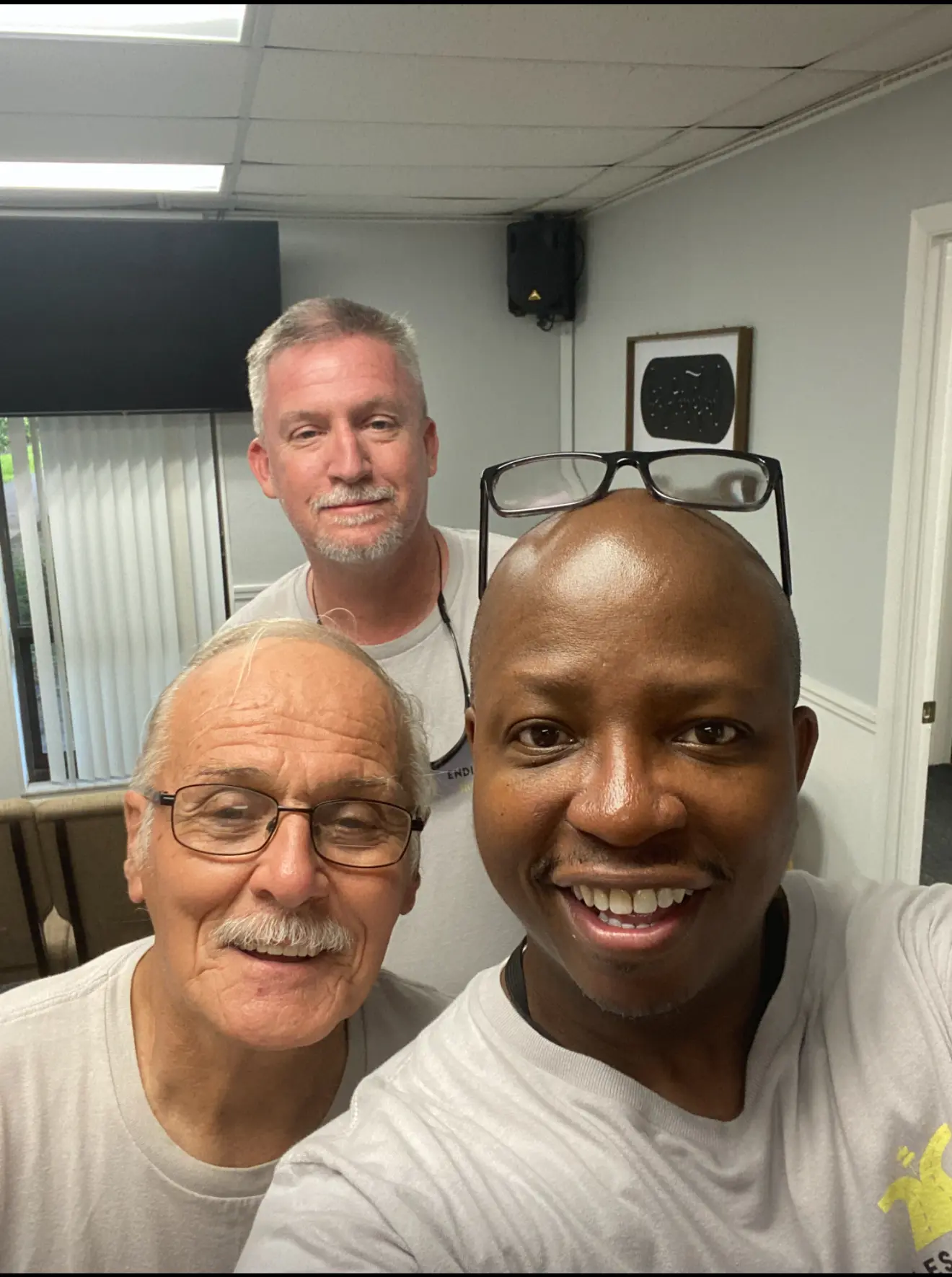 Three men taking a selfie in front of a camera.