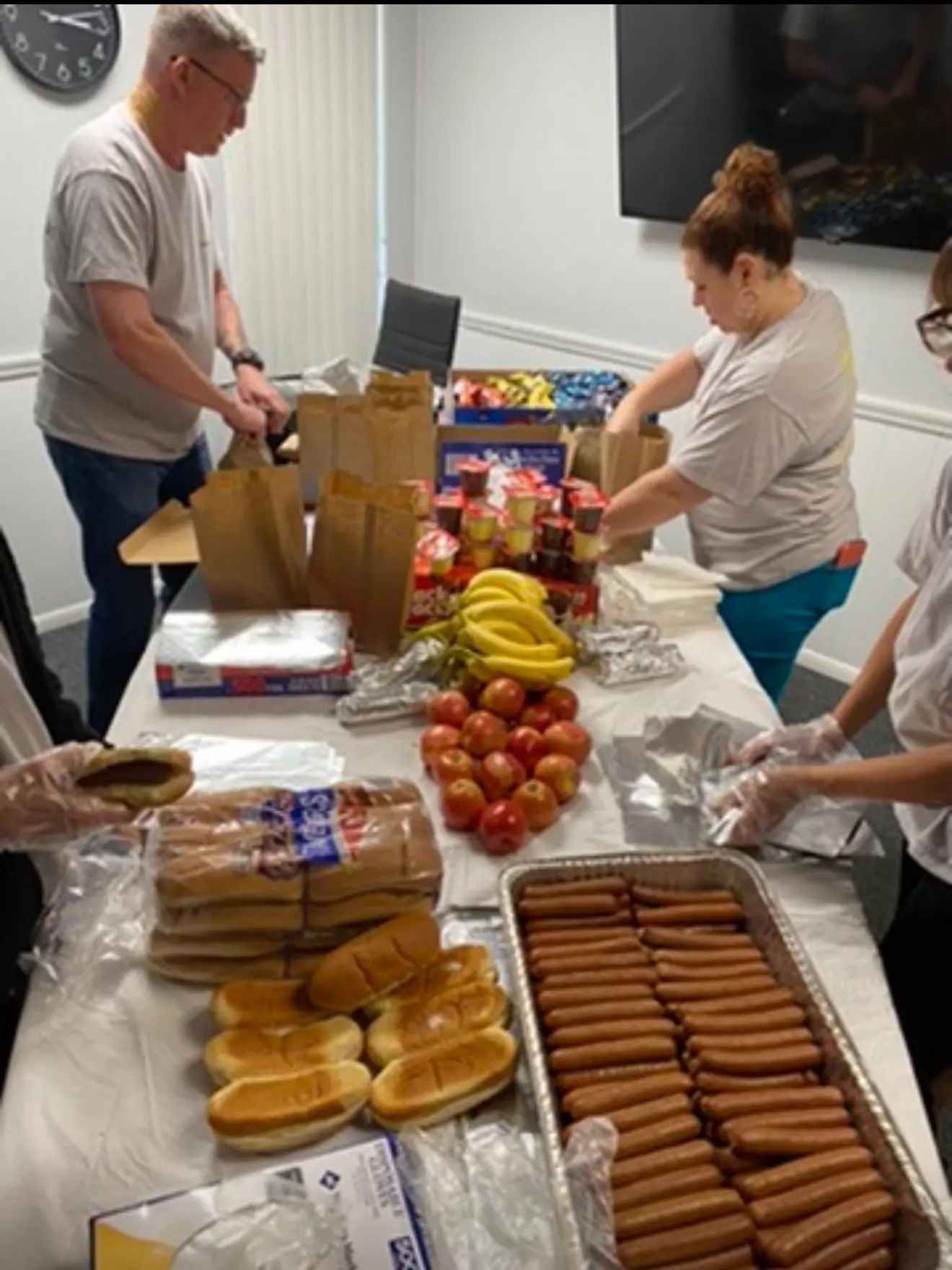 A group of people standing around a table with food.