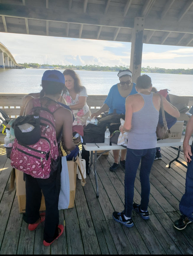 A group of people standing around on the dock.