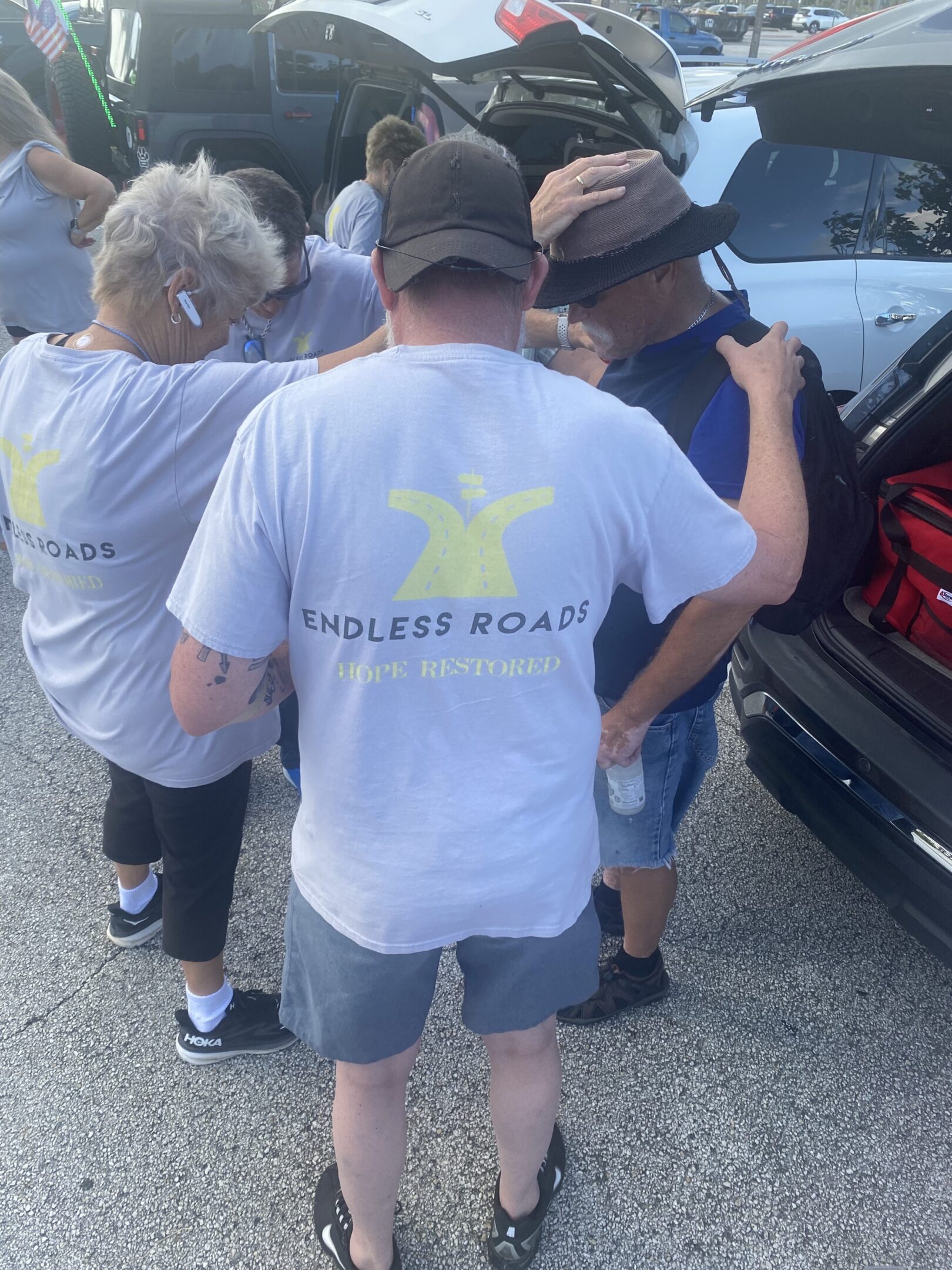 A group of people standing around a car.