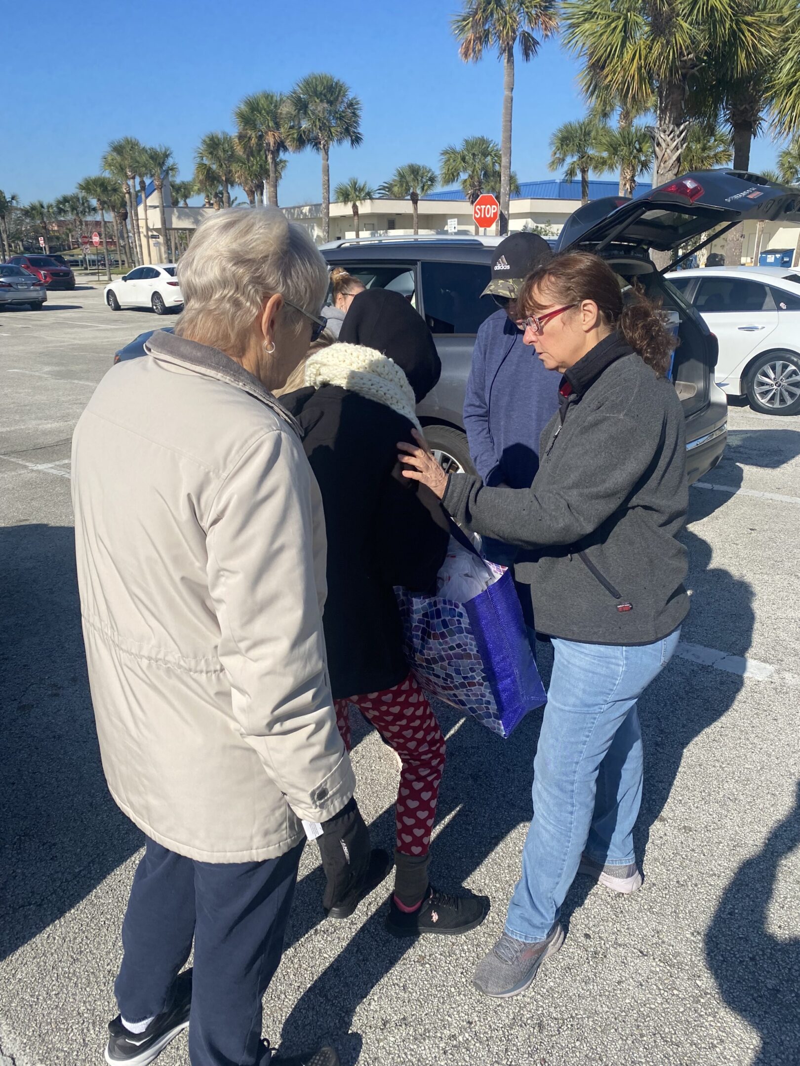 A group of people standing in the parking lot
