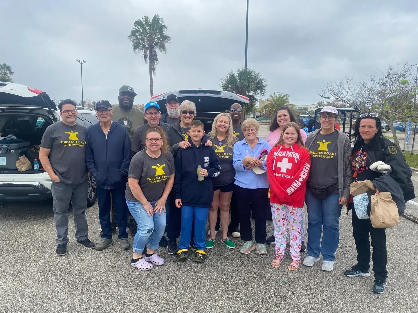 A group of people standing in front of a car.
